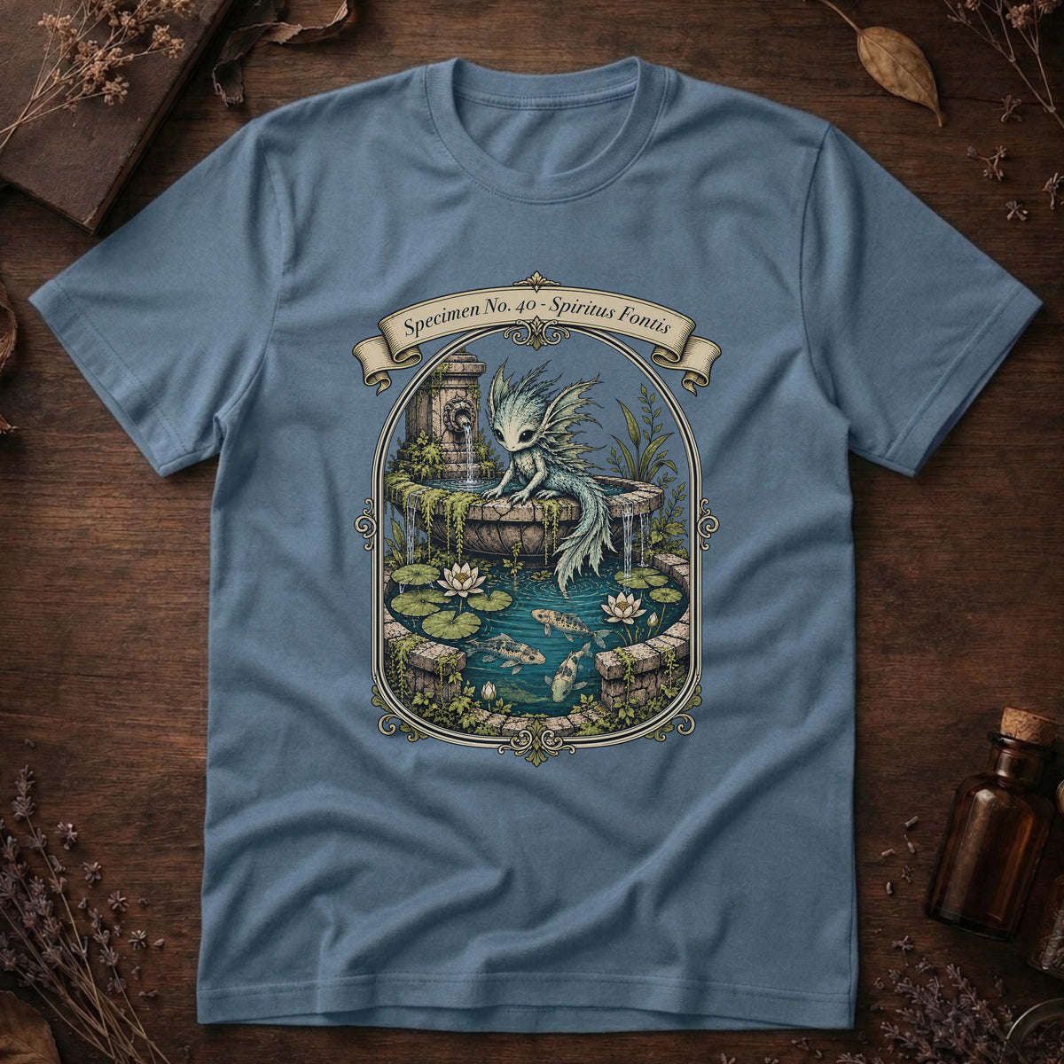Steel blue t-shirt with an ornate illustration of a pale blue water dragon spirit resting on a moss-covered stone fountain among lily pads and koi.