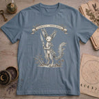 Steel blue t-shirt with a vintage illustration of a winged rabbit-like frost spirit holding a spear, surrounded by botanical linework and a Specimen No. 31 banner.