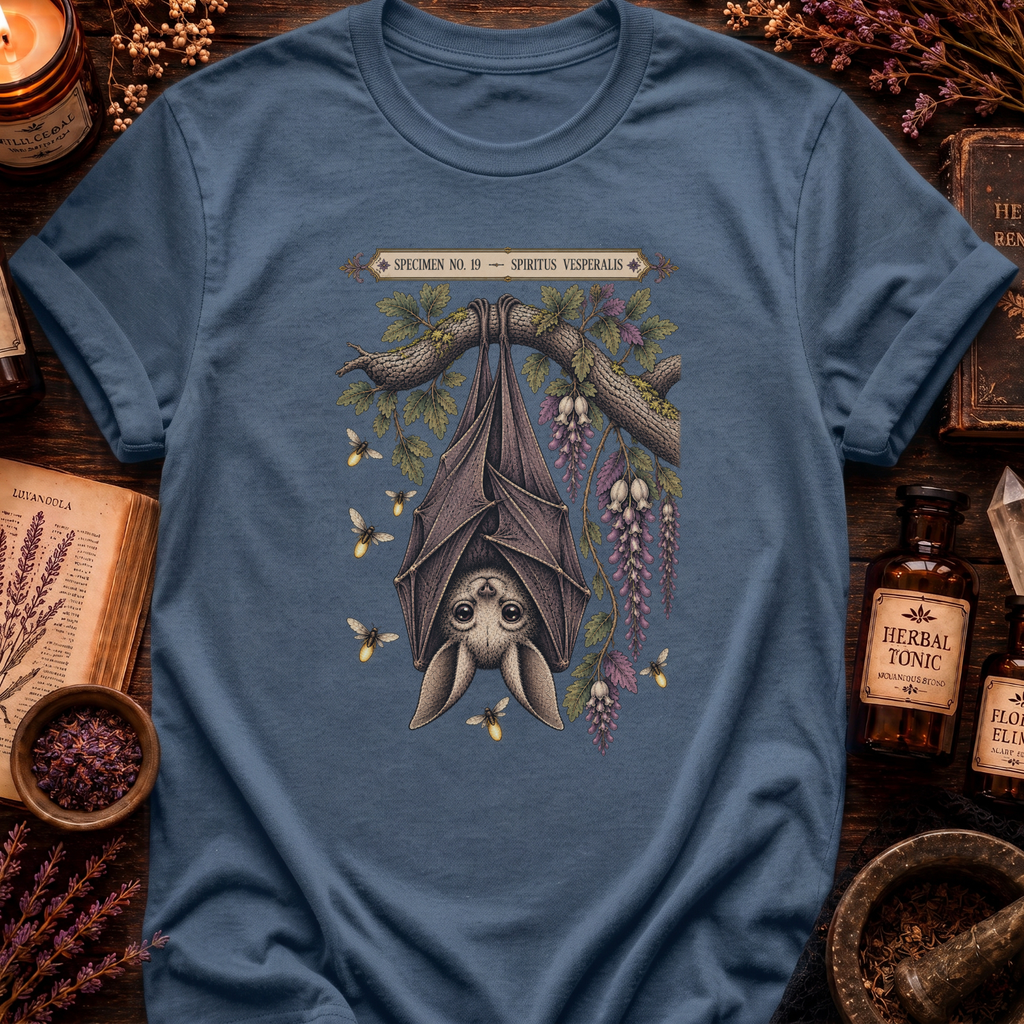 Steel blue t-shirt with a botanical illustration of a hanging bat spirit among wisteria blossoms and bees, framed by a Specimen No. 19 banner.