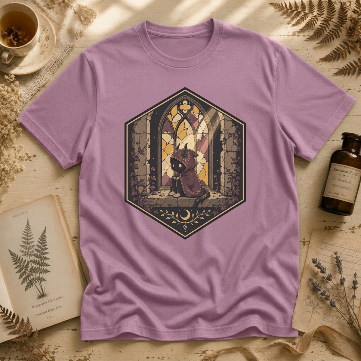Orchid pink t-shirt with a stained-glass window illustration of a small hooded spirit sitting before a Gothic arched window in yellow, purple, and blue glass panels.