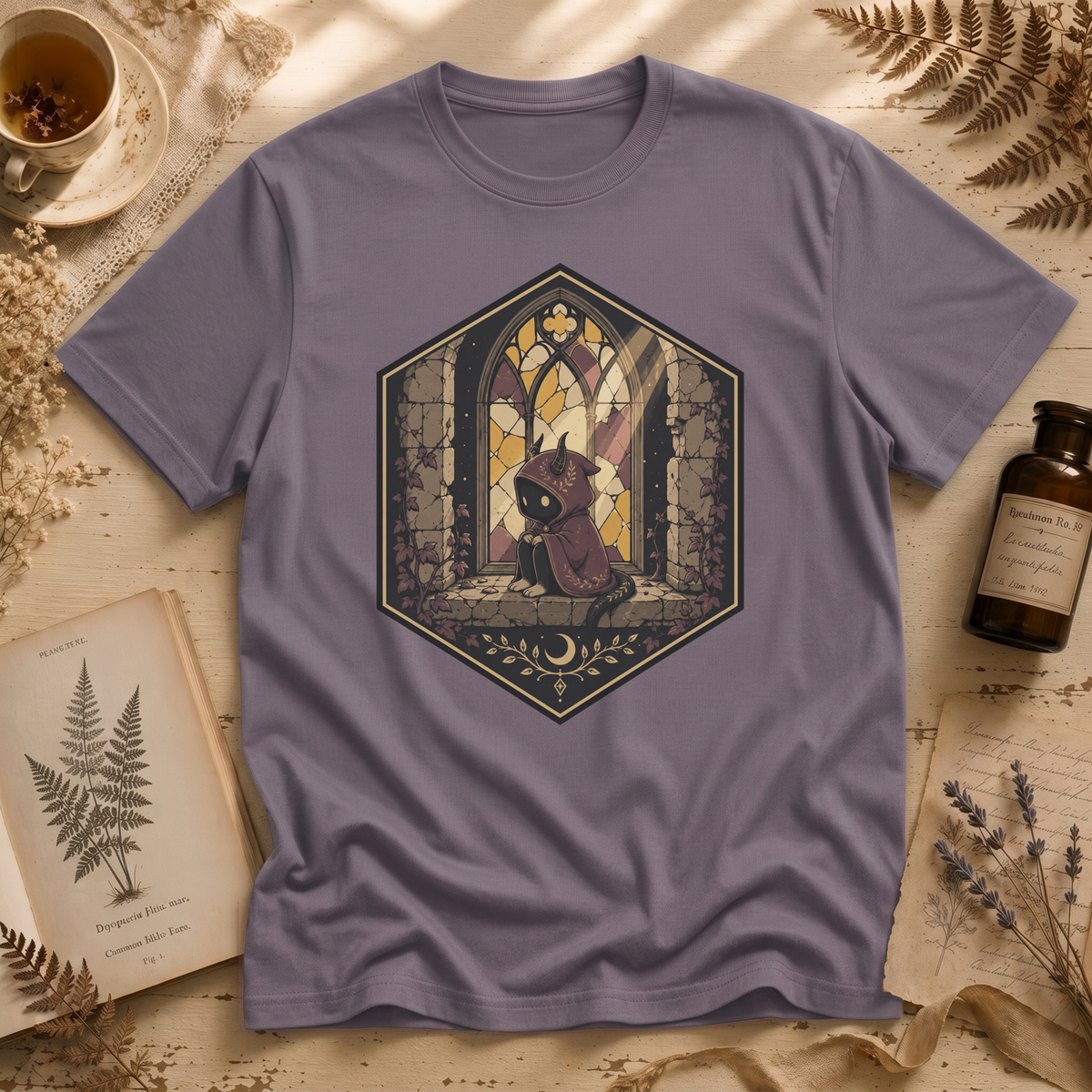 Storm grey t-shirt with a stained-glass window illustration of a small hooded spirit sitting before a Gothic arched window in yellow, purple, and blue glass panels.