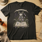 Black t-shirt with a botanical illustration of a skull-faced spirit wearing a floral crown, standing among lavender and bluebell flowers between two open books.