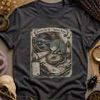 Vintage black t-shirt with a sepia-toned illustration of a sea spirit resting a paw on a brass compass atop an antique nautical map, with a stormy porthole scene above.