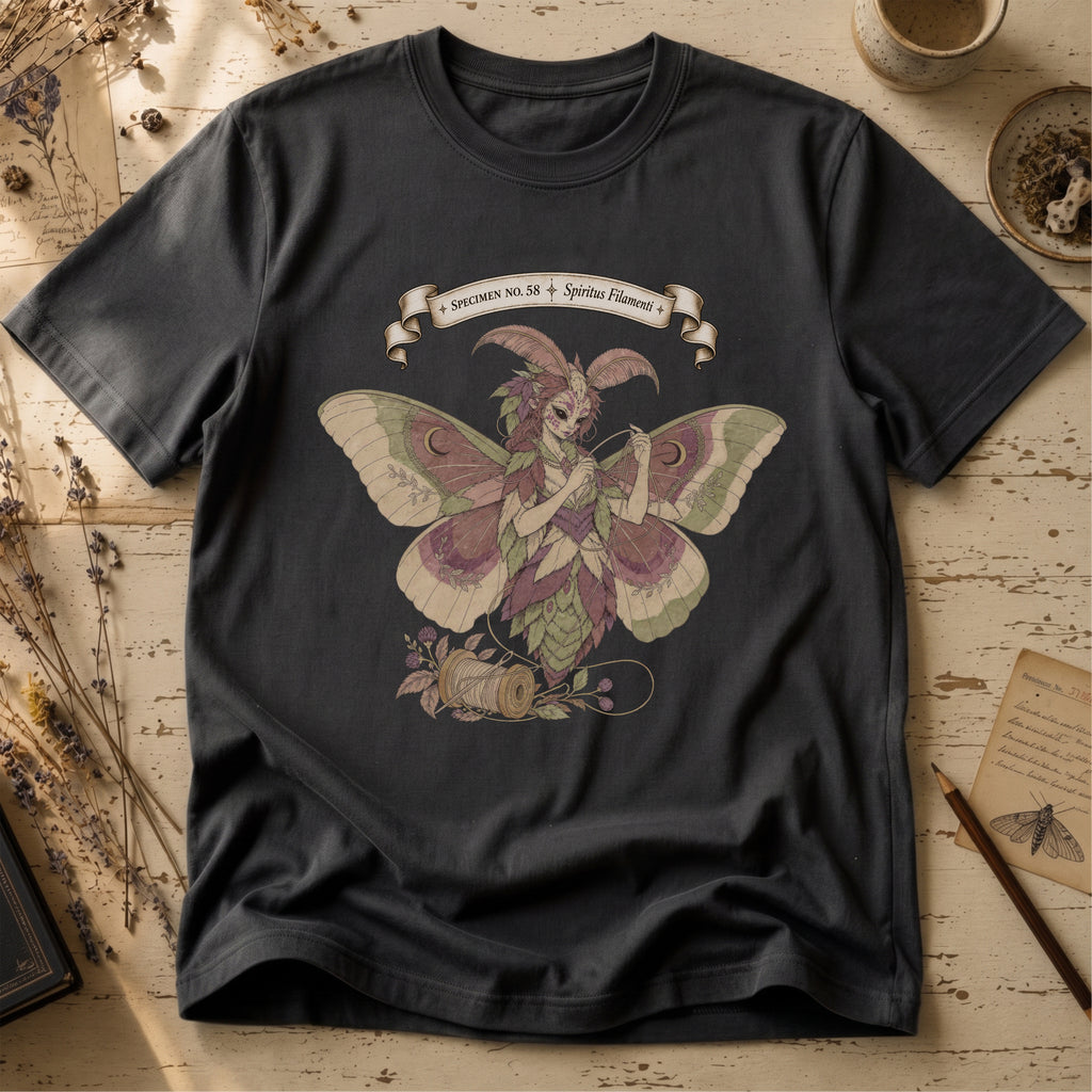 Vintage black t-shirt with an illustration of a moth-winged spirit holding a strand of gold thread beside a spool and needle, surrounded by dusty pink flowers and sage leaves, beneath a banner reading Specimen No. 58.